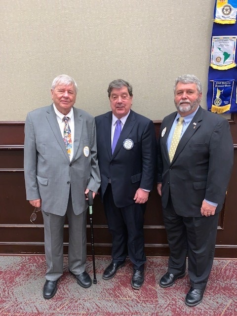 Ken Vaughan (at right) standing with fellow Rotarians